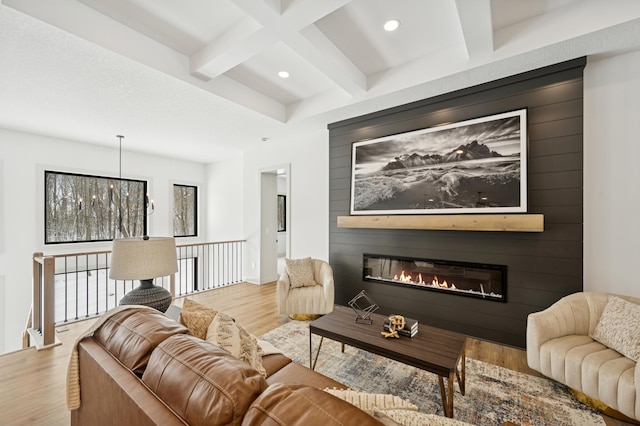 living room featuring a large fireplace, beam ceiling, recessed lighting, wood finished floors, and coffered ceiling