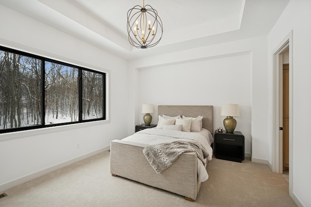 carpeted bedroom with baseboards, a raised ceiling, and an inviting chandelier
