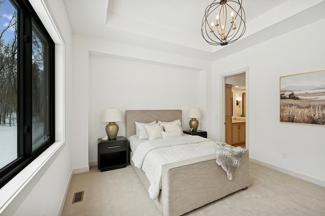 bedroom with a tray ceiling, a notable chandelier, light colored carpet, and visible vents