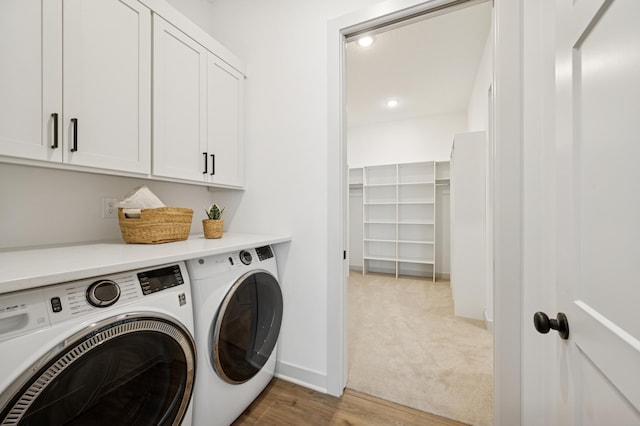 laundry room with light wood-type flooring, washer and dryer, recessed lighting, cabinet space, and baseboards