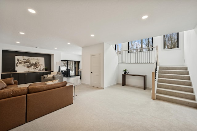 living area with recessed lighting, stairway, light carpet, and baseboards