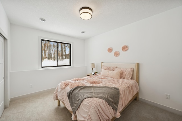carpeted bedroom featuring baseboards and a textured ceiling