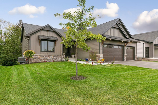 craftsman house featuring cooling unit, a front yard, and a garage