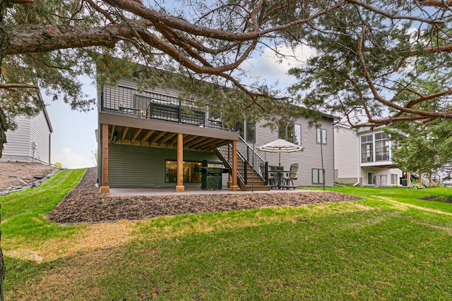 back of property featuring a deck, a lawn, and a patio