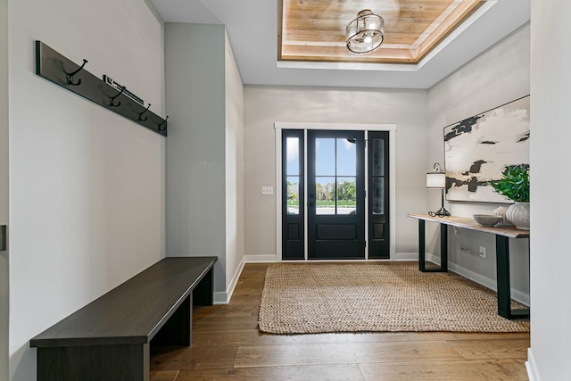 entryway with a raised ceiling, dark wood-type flooring, and wood ceiling