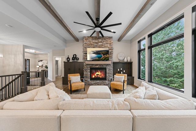 living room with hardwood / wood-style flooring, a fireplace, beam ceiling, and a healthy amount of sunlight