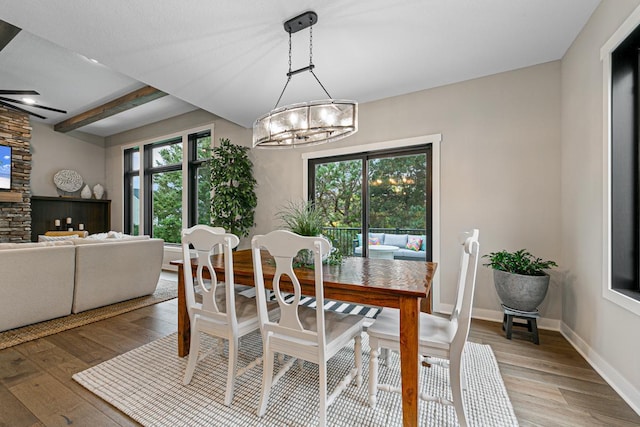 dining room featuring ceiling fan with notable chandelier, beam ceiling, and hardwood / wood-style floors