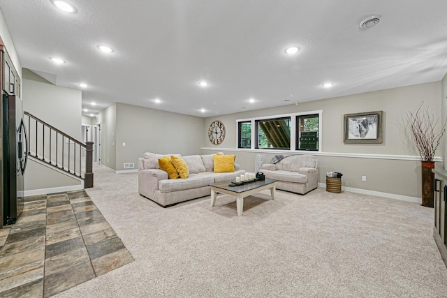 living room with carpet floors, a textured ceiling, and a fireplace