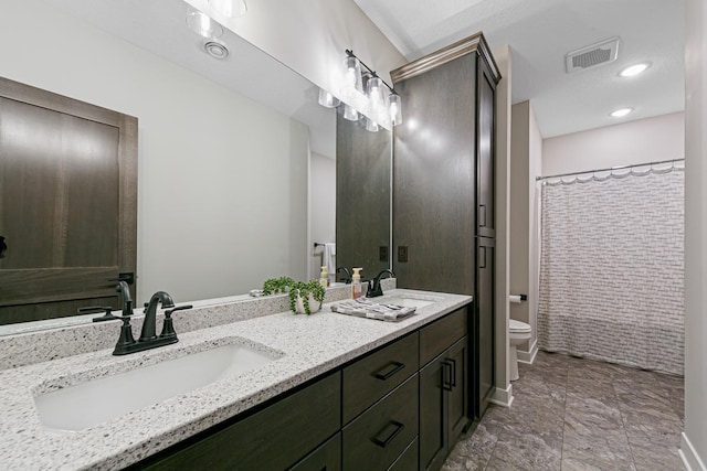 bathroom featuring a shower with curtain, vanity, and toilet