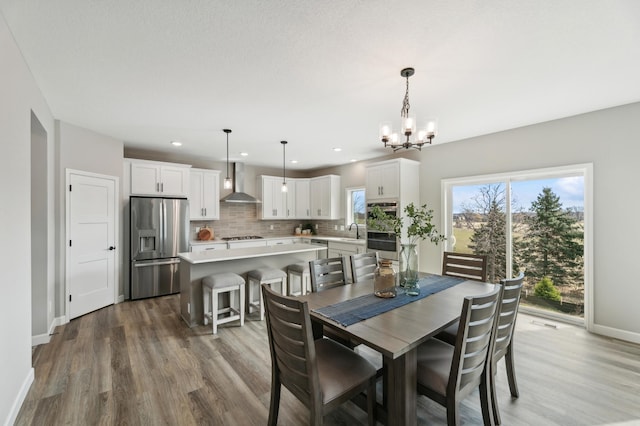 dining area featuring sink, an inviting chandelier, and hardwood / wood-style floors