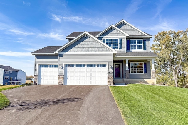 craftsman house featuring a front yard and a garage