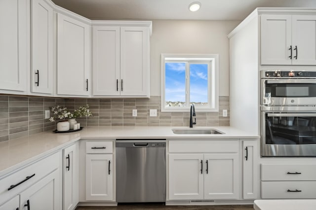 kitchen featuring a sink, stainless steel appliances, light countertops, and white cabinetry