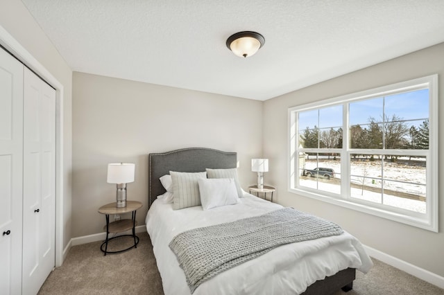 bedroom with carpet floors, baseboards, and a closet