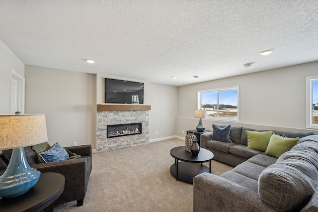 living room with light carpet, a stone fireplace, baseboards, and a textured ceiling