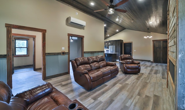 living room featuring ceiling fan with notable chandelier, hardwood / wood-style floors, high vaulted ceiling, and an AC wall unit