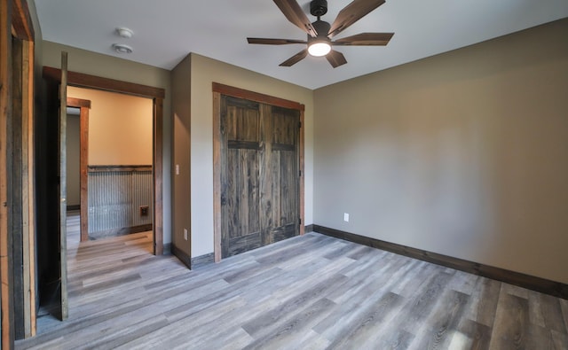 unfurnished bedroom featuring ceiling fan, light hardwood / wood-style flooring, and a closet