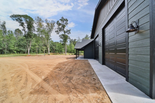 view of yard featuring a carport and a garage