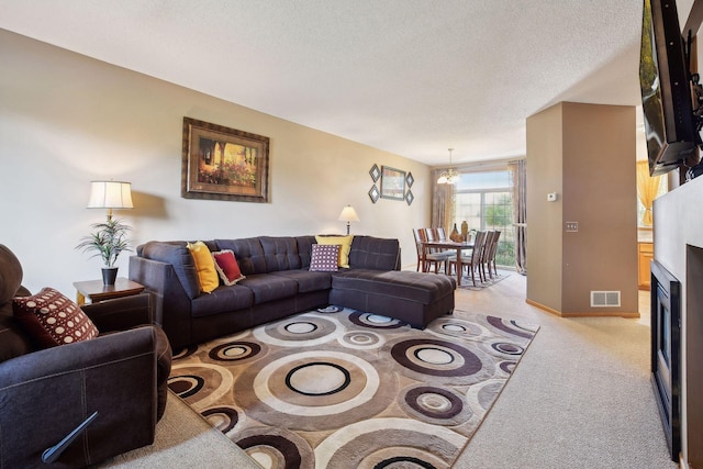 living room featuring light colored carpet, a textured ceiling, and a chandelier