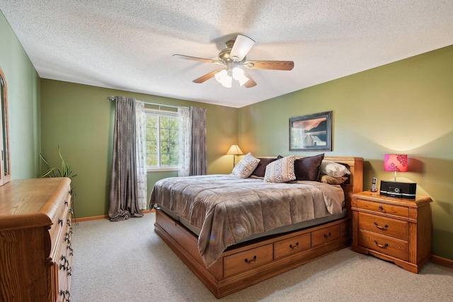 bedroom with ceiling fan, a textured ceiling, and light carpet