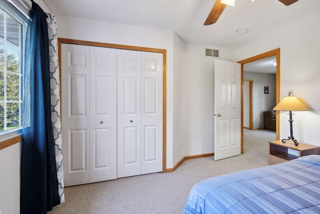 bedroom featuring ceiling fan, carpet floors, a closet, and multiple windows