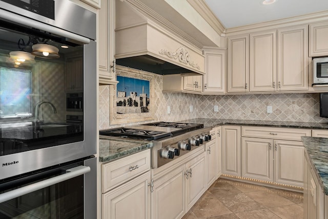 301 22nd St NW, Austin, MN 55912 - kitchen with cream cabinetry, stainless steel appliances, premium range hood, and backsplash