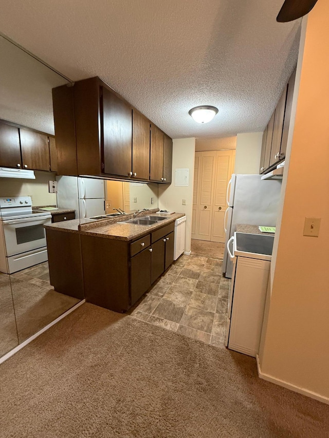 kitchen with dark brown cabinetry, sink, extractor fan, white appliances, and light carpet