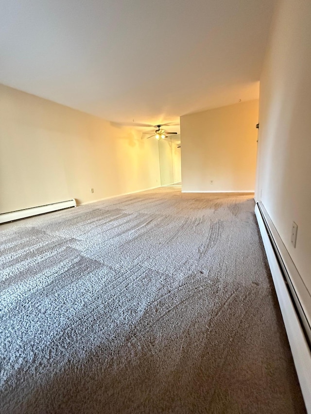 empty room featuring carpet floors, baseboard heating, and ceiling fan