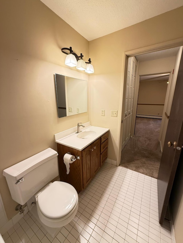 bathroom with tile patterned flooring, vanity, a textured ceiling, and toilet