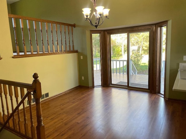 doorway to outside featuring hardwood / wood-style flooring and a notable chandelier