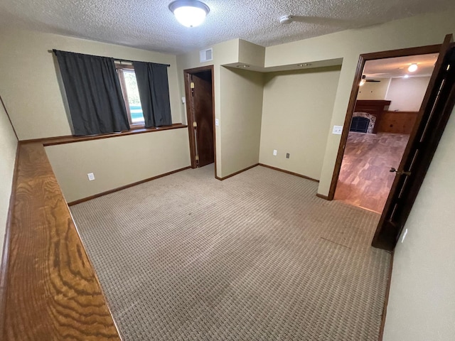 unfurnished bedroom featuring light carpet, a textured ceiling, and a closet