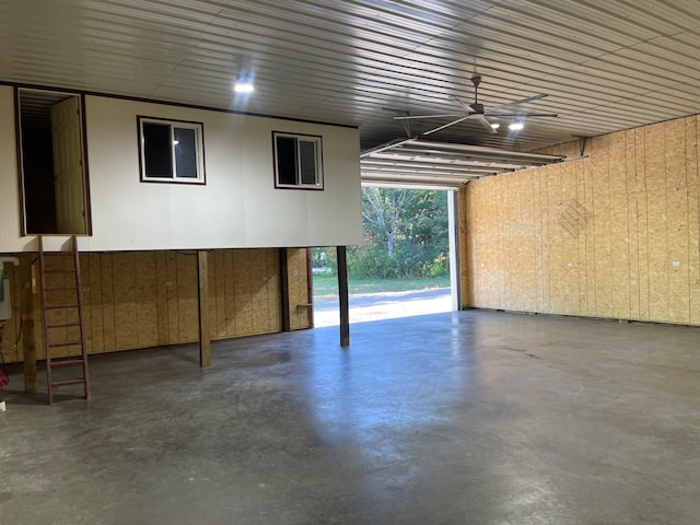 garage with wood walls and ceiling fan