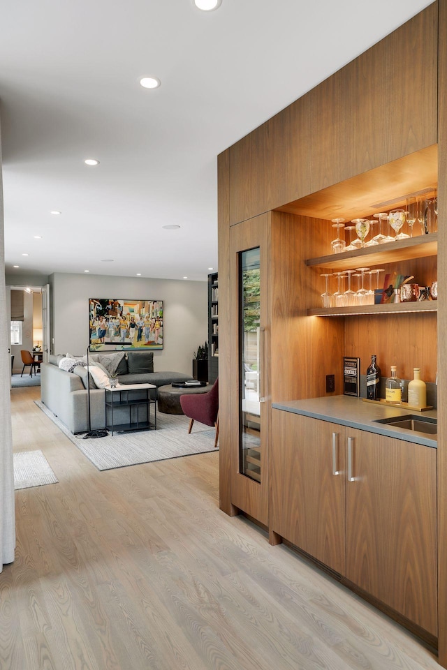 bar featuring wooden walls and light hardwood / wood-style flooring