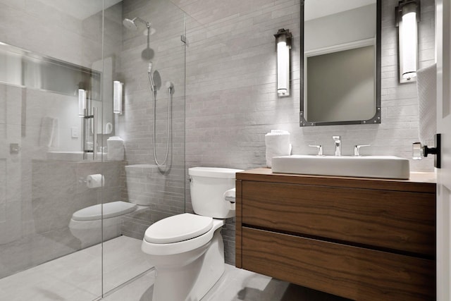 bathroom with vanity, tile walls, toilet, and an enclosed shower