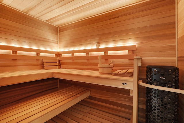 view of sauna featuring wooden ceiling, wood-type flooring, and wooden walls