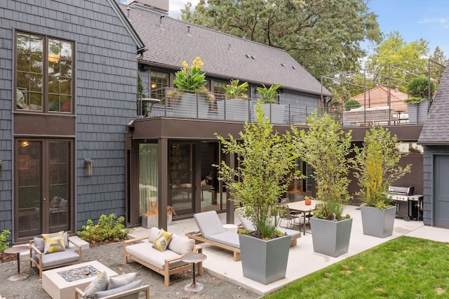 back of property featuring a balcony, an outdoor living space, and a patio