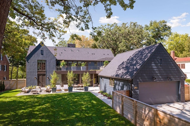 back of house featuring a lawn and a balcony