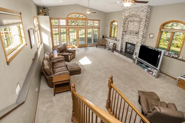 carpeted living room with a brick fireplace, lofted ceiling, and ceiling fan