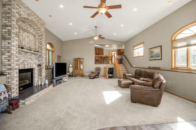 carpeted living room featuring lofted ceiling, a fireplace, and ceiling fan