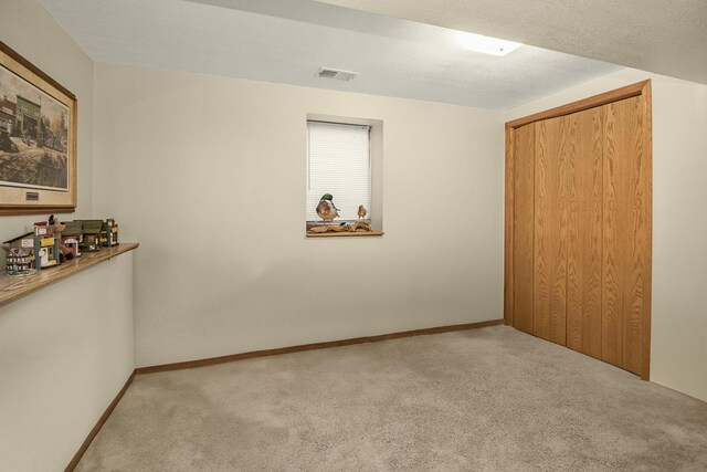 carpeted empty room with a textured ceiling