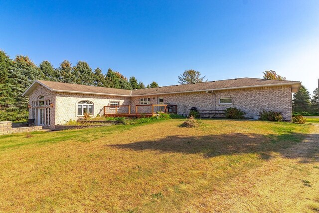 back of property featuring a yard and a deck