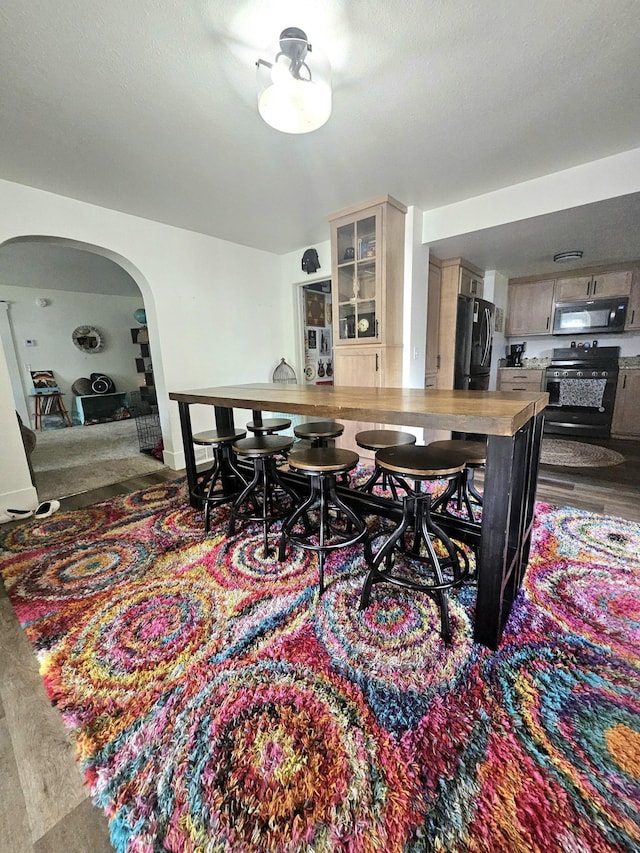 dining room featuring wood-type flooring and a textured ceiling