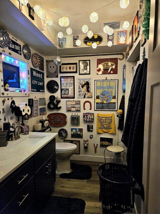 bathroom with vanity, toilet, and hardwood / wood-style flooring