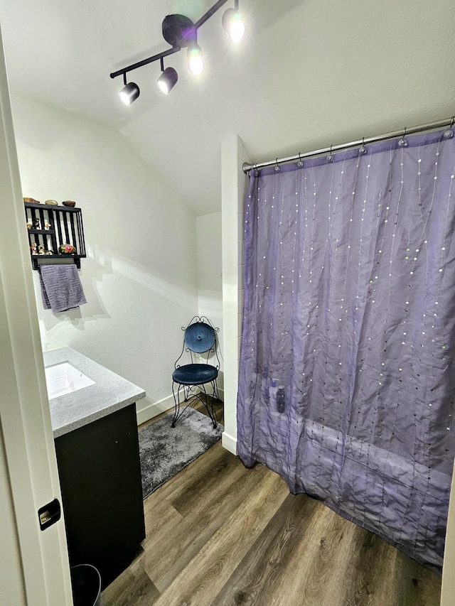 bathroom featuring vanity, hardwood / wood-style floors, and vaulted ceiling