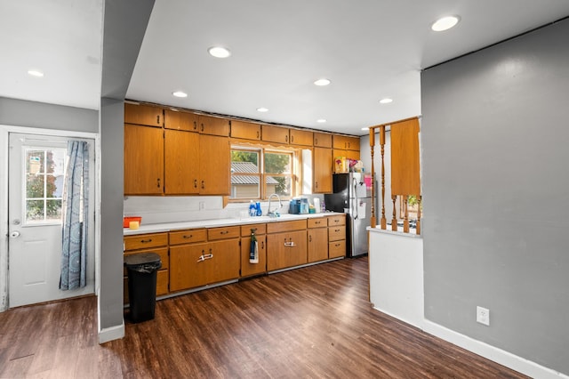 kitchen featuring stainless steel refrigerator, sink, dark hardwood / wood-style flooring, and a healthy amount of sunlight