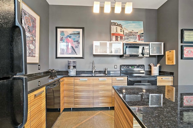 kitchen featuring dark stone counters, black appliances, and sink