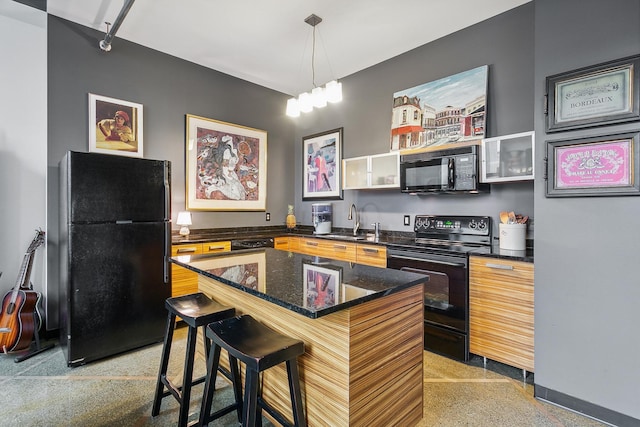 kitchen featuring a breakfast bar, black appliances, a center island, sink, and a notable chandelier