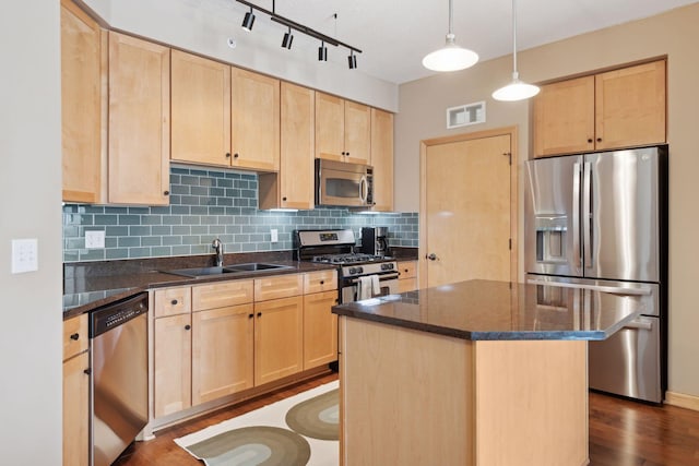 kitchen featuring stainless steel appliances, light brown cabinets, a sink, and visible vents