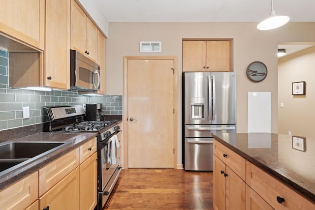 kitchen featuring pendant lighting, stainless steel appliances, visible vents, light wood-style flooring, and light brown cabinetry