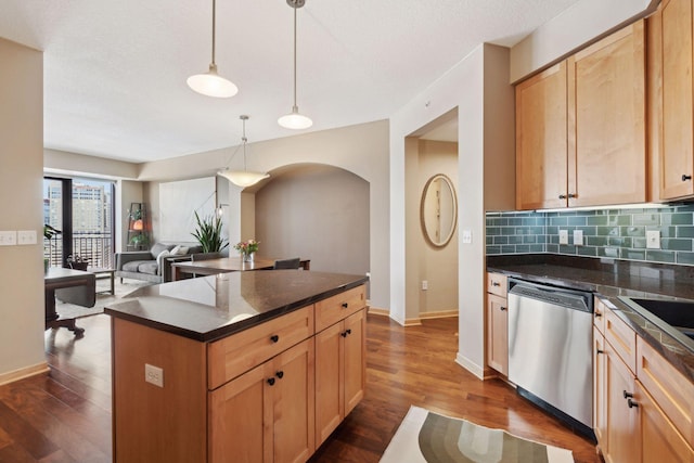 kitchen with dark wood finished floors, dishwasher, dark countertops, pendant lighting, and backsplash