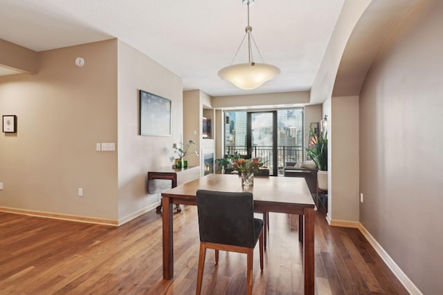 dining area featuring dark wood-style flooring and baseboards